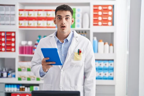 Hombre Hispano Guapo Trabajando Farmacia Con Tableta Asustado Sorprendido Con —  Fotos de Stock