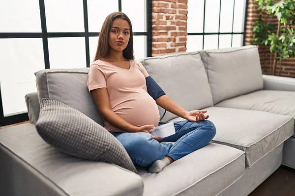 Young Pregnant Woman Using Blood Pressure Monitor Sitting Sofa Looking — Stok fotoğraf