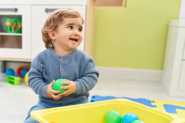 可敬的是 他的惊慌失措的幼儿在幼儿园的地板上玩着球 — 图库照片