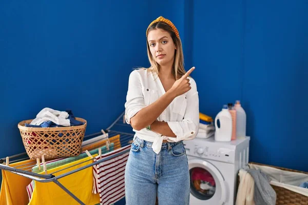 Ung Blond Kvinna Tvättstugan Pekar Med Handfingret Sidan Visar Reklam — Stockfoto