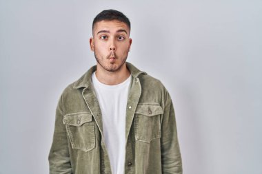 Soyutlanmış arka planda duran genç İspanyol adam dudaklarıyla balık yüzü yapıyor, çılgınca ve komik bir jest. Komik ifade. 