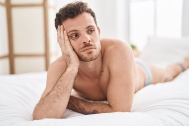 Genç İspanyol adam yatak odasında rahat bir ifadeyle yatakta yatıyor.