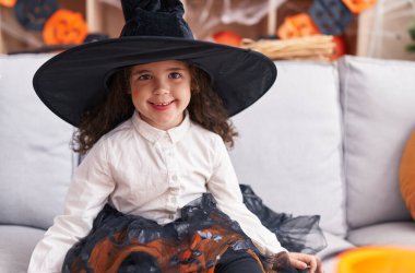 Adorable hispanic girl smiling confident wearing halloween costume at home