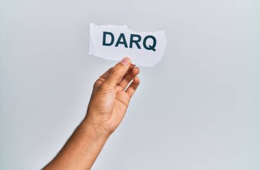 Hand of caucasian man holding paper with darq word over isolated white background