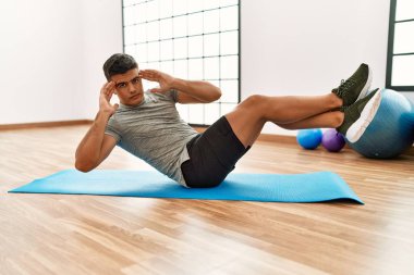 Spor merkezinde karın kaslarını çalıştıran genç bir İspanyol.