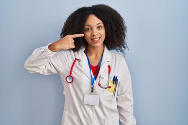 Genç Afro-Amerikan kadın doktor üniforması giyiyor ve steteskop ile el ele ve burun buruna bakıyor, neşeyle gülümsüyor. güzellik konsepti 