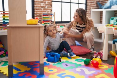 Teacher and toddler playing at kindergarten