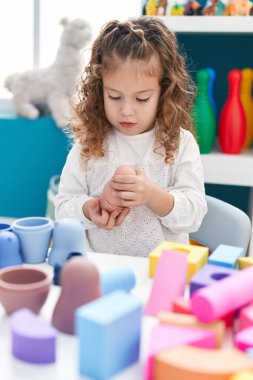 Sevimli sarışın çocuk anaokulunda oyuncaklarla oynuyor.