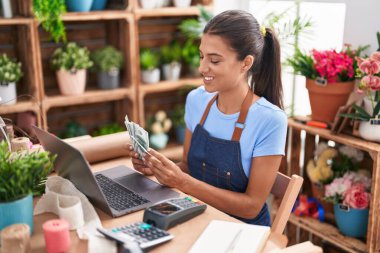 Çiçekçiye para sayan güzel İspanyol kadın.