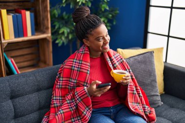 Afrikalı Amerikalı kadın yeni evinde karton kutu paketliyor.