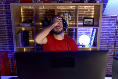 İspanyol asıllı genç adam oyun odasında bilgisayar kullanarak strese girdi.