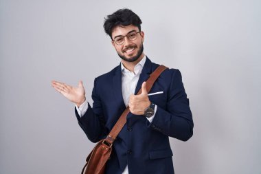 Hispanic man with beard wearing business clothes showing palm hand and doing ok gesture with thumbs up, smiling happy and cheerful 