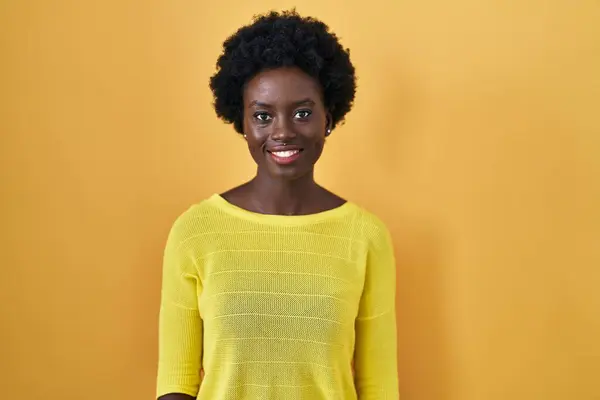 Afrikansk Ung Kvinna Står Över Gul Studio Blinkar Tittar Kameran — Stockfoto