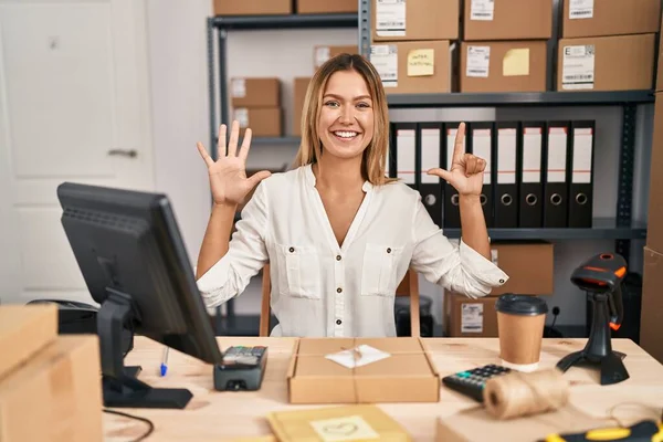 Młoda Blondynka Pracuje Małym Biznesie Commerce Pokazując Wskazując Palcami Numer — Zdjęcie stockowe