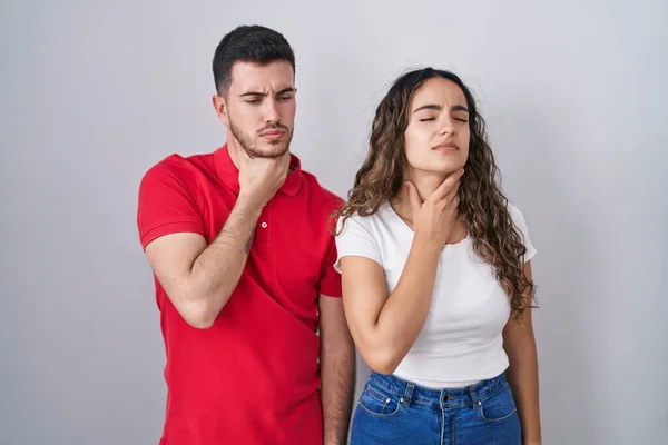 Young Hispanic Couple Standing Isolated Background Touching Painful Neck Sore — Zdjęcie stockowe