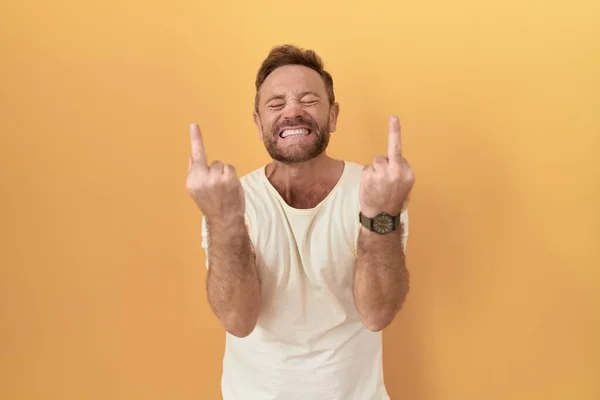 Middle Age Man Beard Standing Yellow Background Showing Middle Finger — Stockfoto