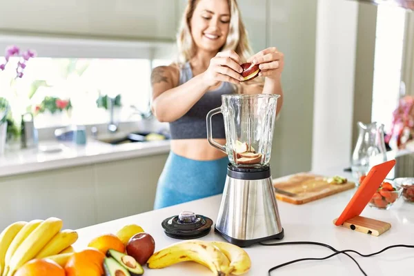 Young Woman Looking Online Juice Recipe Pouring Apple Blender Kitchen — Stok fotoğraf
