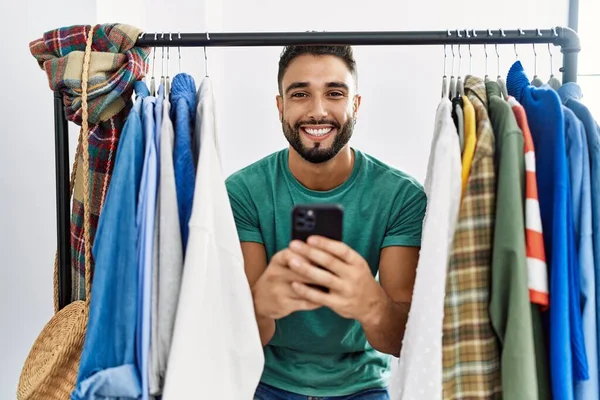 Young Arab Man Customer Using Smartphone Appearing Clothes Rack Clothing — Stock Photo, Image