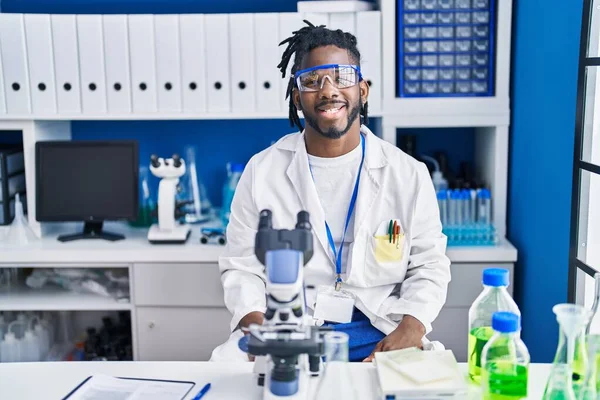 科学研究所で働いているアフリカ人のドレッドロックの男は 顔に幸せとクールな笑顔で 運のいい人 — ストック写真