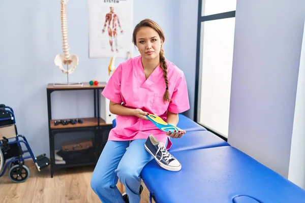 Young Hispanic Woman Holding Shoe Insole Physiotherapy Clinic Relaxed Serious — Fotografia de Stock