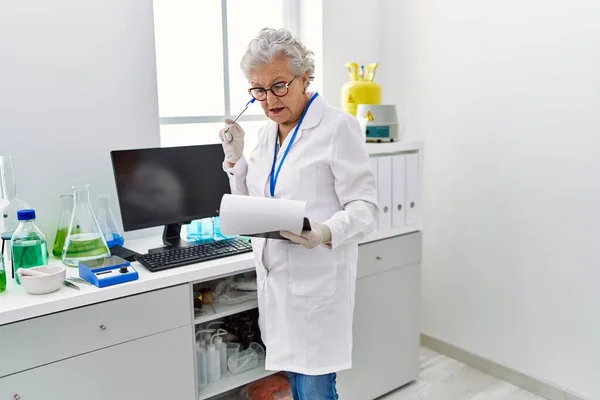 Oudere Grijsharige Vrouw Wetenschapsuniform Met Twijfelachtige Uitdrukking Laboratorium — Stockfoto