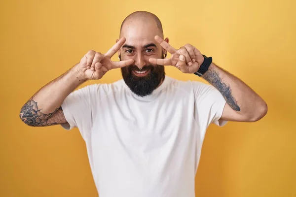 Young Hispanic Man Beard Tattoos Standing Yellow Background Doing Peace —  Fotos de Stock
