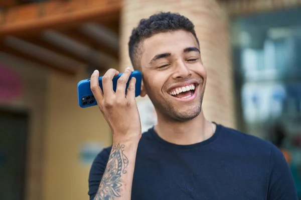 Afrikkalainen Amerikkalainen Mies Hymyilee Luottavainen Kuuntelee Ääniviestin Älypuhelimen Kadulla — kuvapankkivalokuva