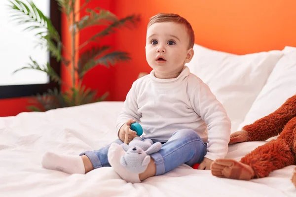 愛らしいですCaucasian赤ん坊遊びますとともにおもちゃ座りでベッドルーム — ストック写真