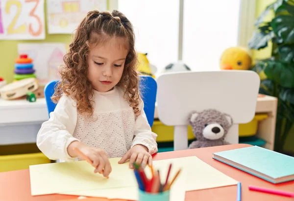可爱的金发碧眼的学龄前儿童坐在桌子上 在幼儿园用纸画画 — 图库照片