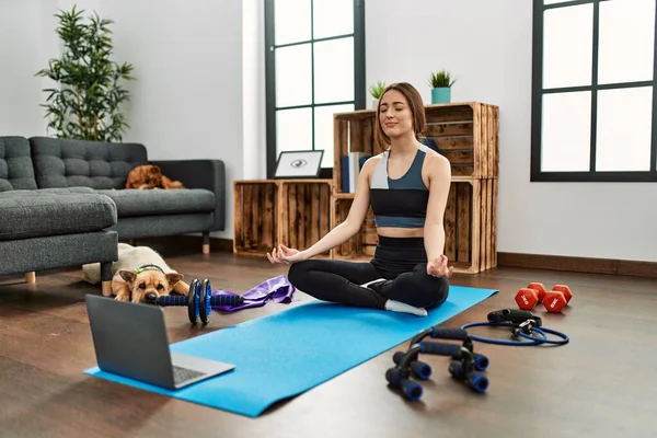 Evde yoga dersi aldığı için kendinden emin gülümseyen genç İspanyol kadın.