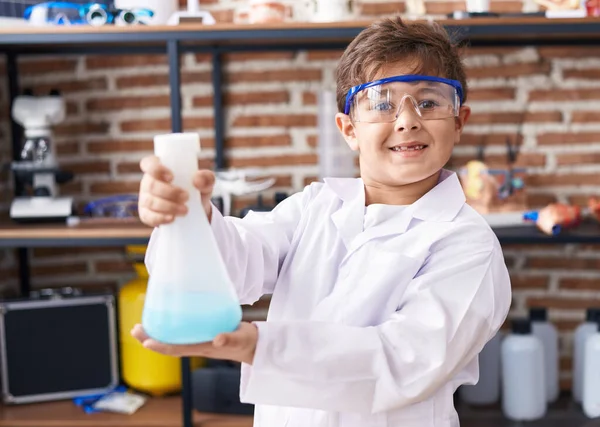 可敬的惊慌失措的男孩微笑着 自信地拿着试管在实验室教室里 — 图库照片