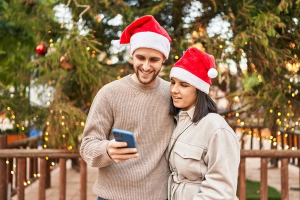 Pareja Hombres Mujeres Con Sombrero Navidad Usando Smartphone Parque —  Fotos de Stock