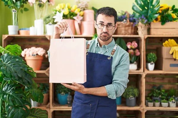 Handsome hispanic man working at florist shop depressed and worry for distress, crying angry and afraid. sad expression. 