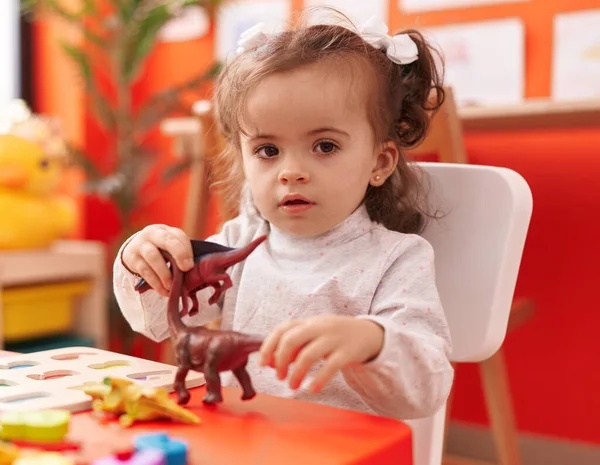유치원 테이블에 앉아서 장난감을 가지고 스러운 잠꾸러기 — 스톡 사진