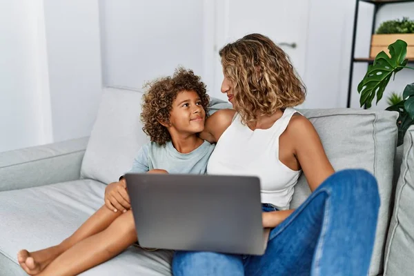 Mother and son hugging each other using laptop at home