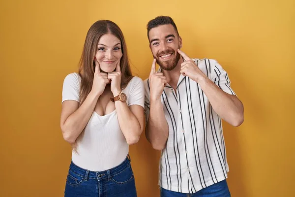 Young Couple Standing Yellow Background Smiling Open Mouth Fingers Pointing — 图库照片