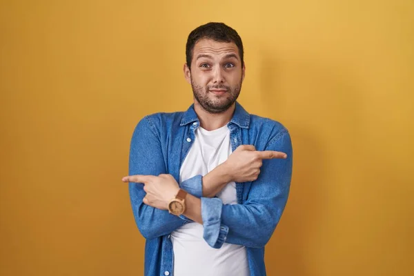 Hispanic Man Standing Yellow Background Pointing Both Sides Fingers Different — Stock Photo, Image