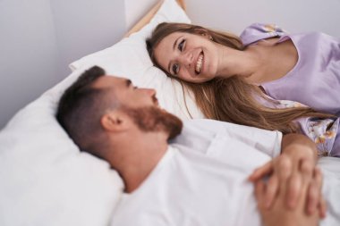 Man and woman couple smiling confident lying on bed at bedroom