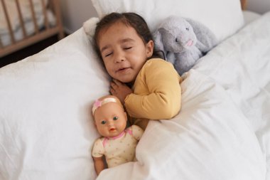 Adorable hispanic toddler lying on bed sleeping at bedroom