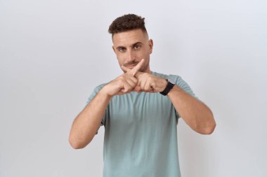 Hispanic man with beard standing over white background rejection expression crossing fingers doing negative sign 