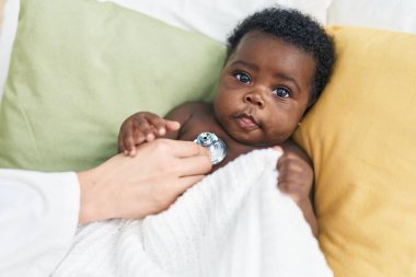 Afrika kökenli Amerikalı bebek yatak odasında muayene oluyor.