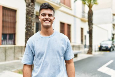 Sokakta kendinden emin gülümseyen İspanyol genç adam.