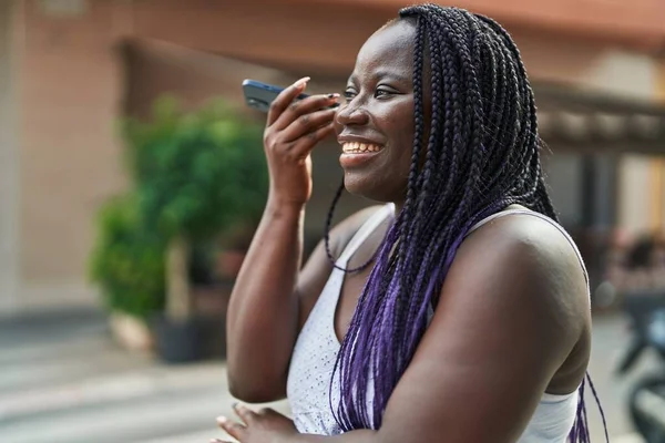 非洲裔美国妇女微笑着 自信地听着智能手机在咖啡店平台上的音频信息 — 图库照片