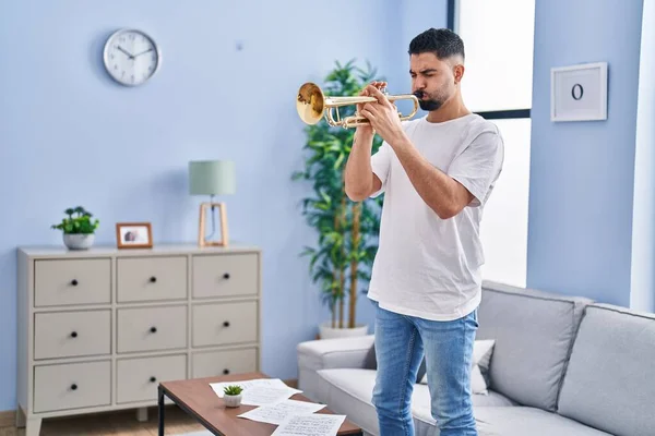 年轻的阿拉伯男子音乐家站在家里吹喇叭 — 图库照片