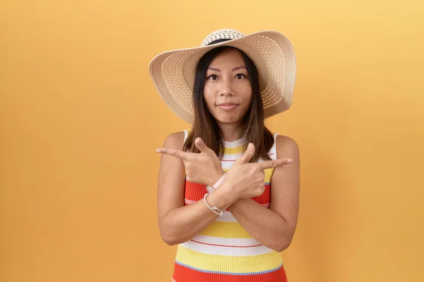 Middle Age Chinese Woman Wearing Summer Hat Yellow Background Pointing — ストック写真