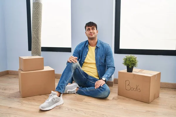 Young Hispanic Man Sitting Floor New Home Smiling Looking Side — Stockfoto