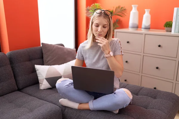 Junge Blonde Frau Benutzt Laptop Mit Zweifelhaftem Ausdruck Hause — Stockfoto