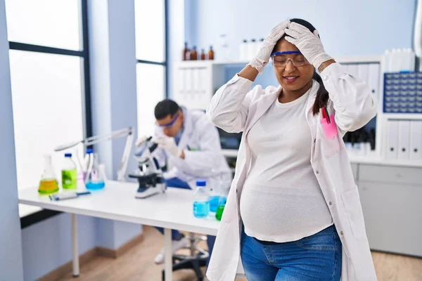 Young Hispanic Woman Expecting Baby Working Scientist Laboratory Suffering Headache — ストック写真