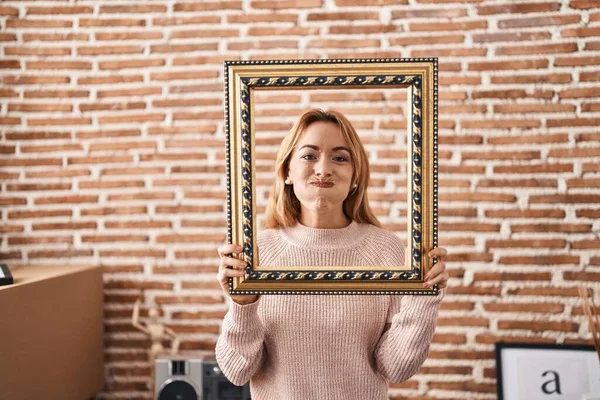 Hispanic Woman Holding Empty Frame Puffing Cheeks Funny Face Mouth — Stock Photo, Image
