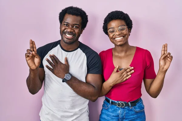 Young African American Couple Standing Pink Background Smiling Swearing Hand — Stock Photo, Image